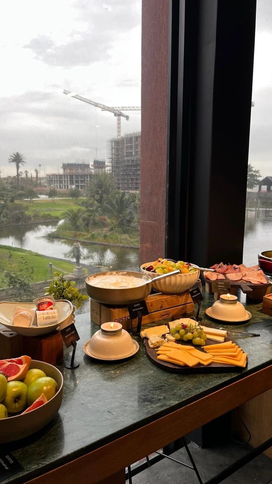 Fruit, cheese and yoghurt by a window looking out over the water