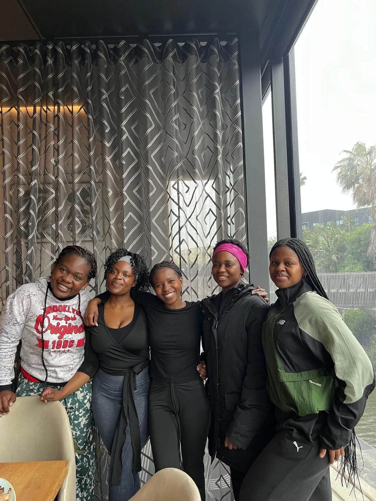 Five women smiling arm in arm at the Holy Girl Brunch