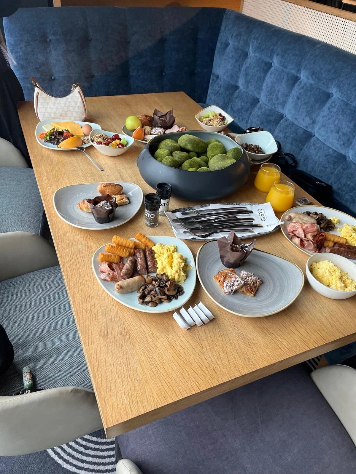 A brunch table laid with pastries, fruit and fresh juice