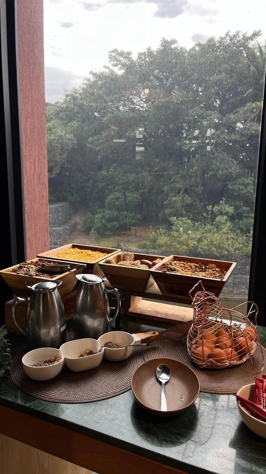 The cereal and granola bar by a rainy window