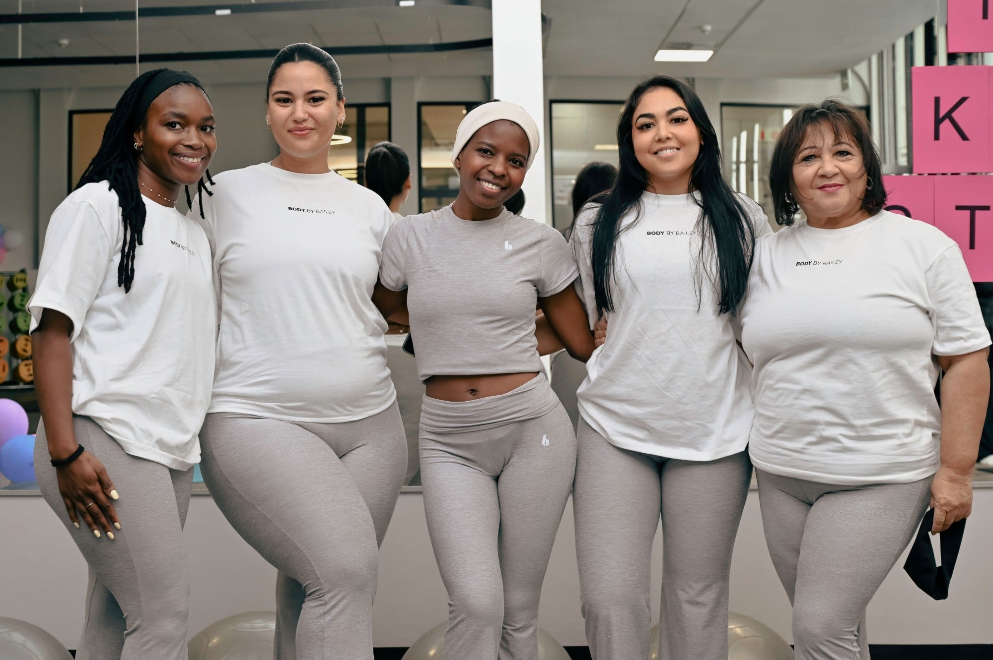 Five women smiling arm in arm